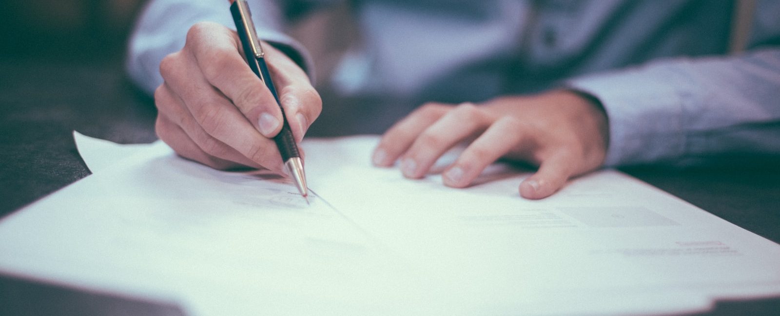 man writing on paper