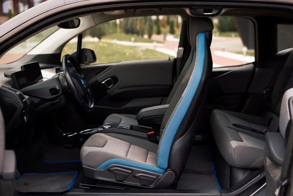 A sleek interior of a modern car showcasing the front and rear seats and steering wheel details